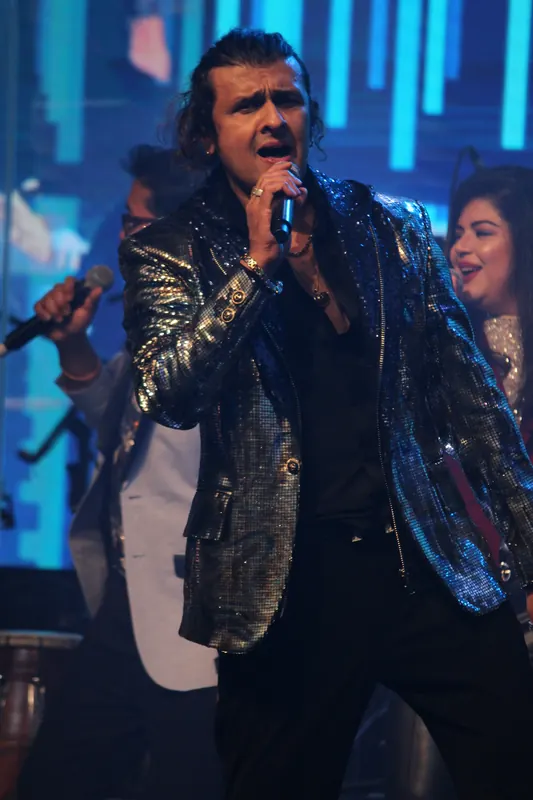 Singer mid-song in a sequinned jacket
