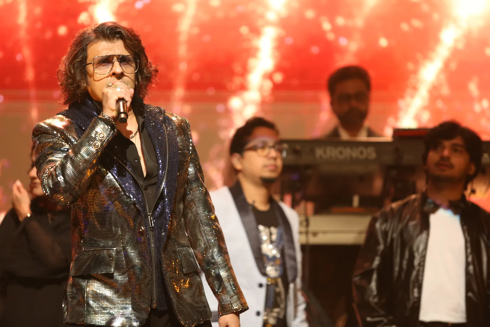 Vocalist at the front of stage with the band behind
