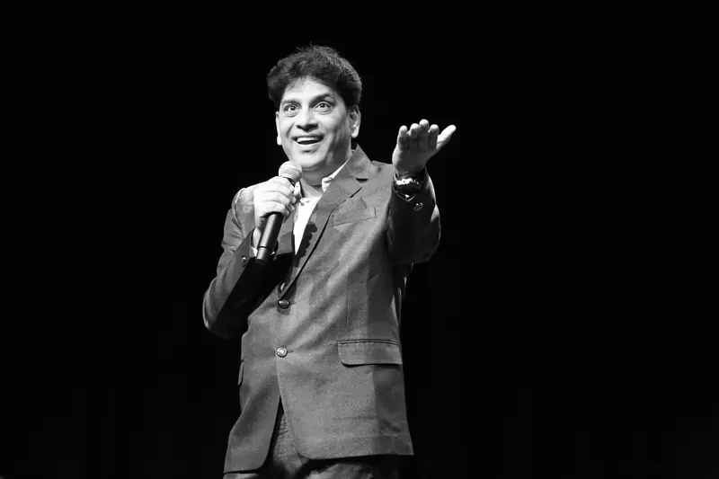 Performer mid-set against a black backdrop, black and white