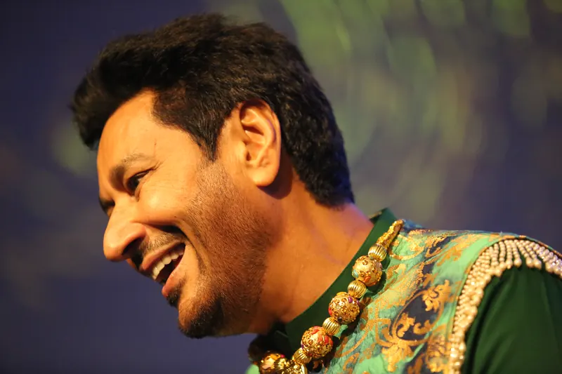 Singer in profile, caught mid-laugh on stage